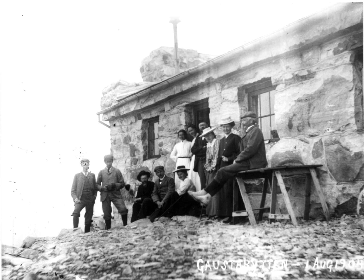 Friluftsliv, Gaustatoppen, Tinn, Telemark, 1.august, 1904. Gruppe kvinner og menn i sportsdrakter foran steinbygning,