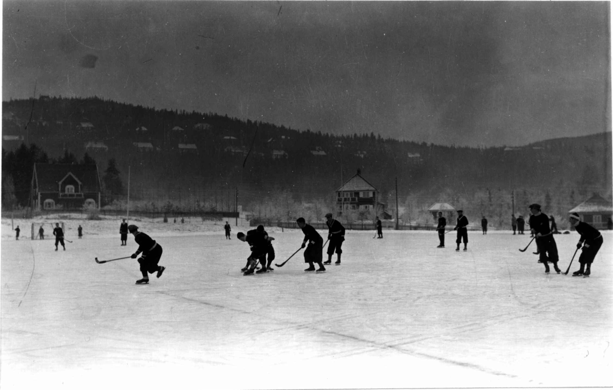 Skøyter. 1935. Bandy spilles på Gressbanen.
Holmenkollåsen i bakgrunnen.