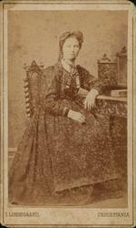 Visittkort. Portrett av kvinne sittende på stol.