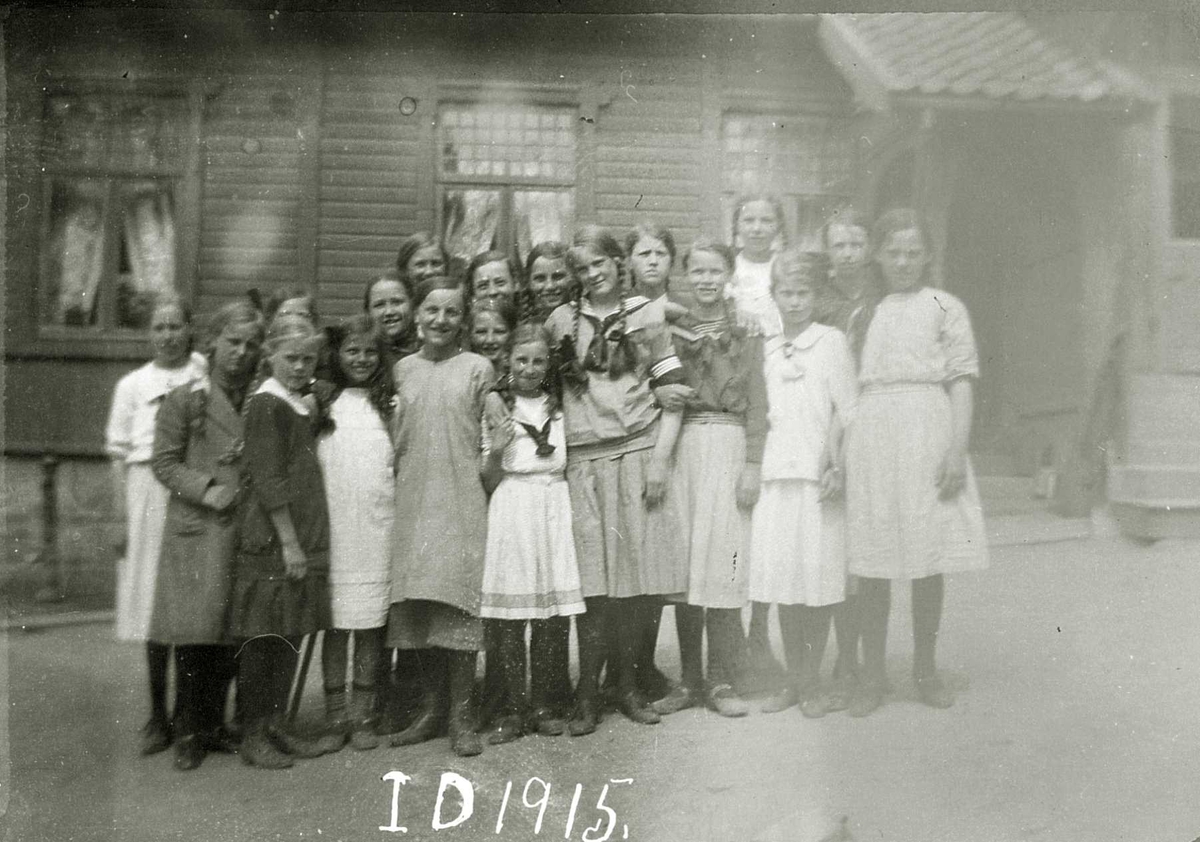 Fra Hjørdis Fouglis (pikenavn Junker) barneår. Fra klasse 1D på Arendal Middelskole, Arendal, Aust-Agder, 1915. Hjørdis i hvit kjole i midten første rekke.