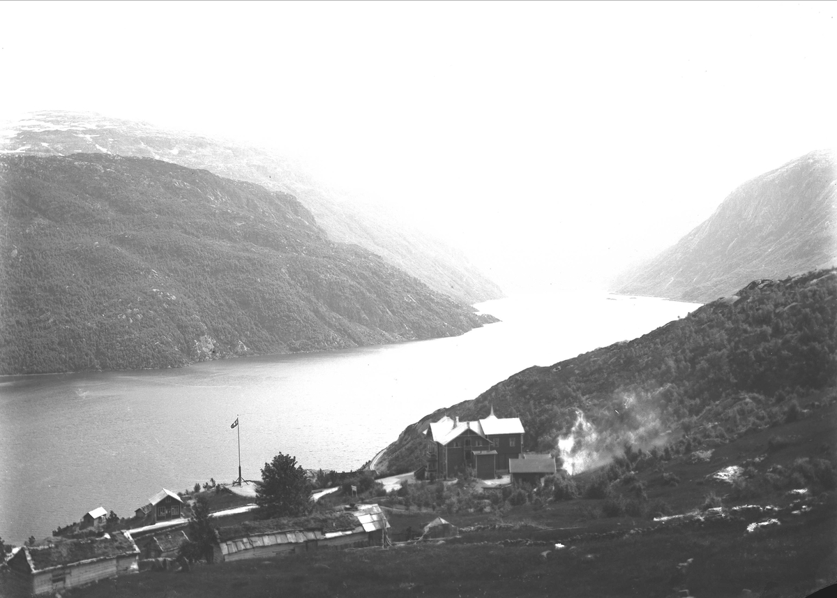 Landskapsfotografi. Fjell, fjord og bebyggelse. Breifonn i Odda med Røldalsvatnet i bakgrunnen.