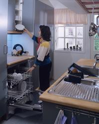 En kvinne rydder ut av oppvaskmaskin. lllustrasjonbilde fra 