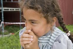 Levendegjøring på museum.Jente som plyster i et gresstrå.
