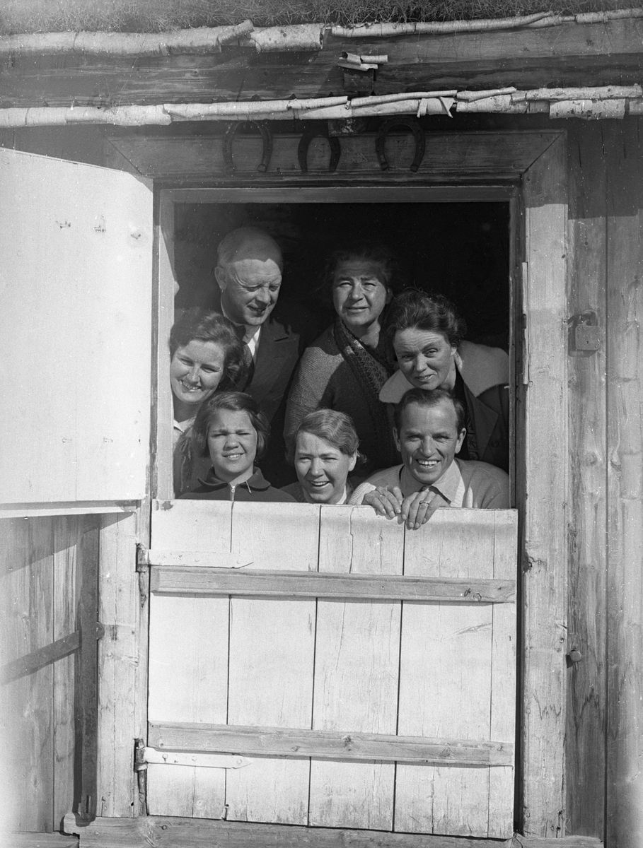 Dordi og Fritjof Arentz står i døråpningen sammen med noen andre personer i en hytte, Mysusæter.  Fotografert påsken 1932.