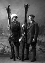 Gruppeportrett, mann og kvinne i skiutstyr i studio. Begge i