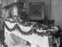 Post mortem-fotografi. Kvinne i pyntet kiste, maleri av avd