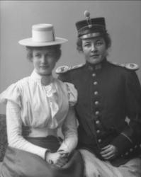 Gruppeportrett, to unge kvinner. Den ene utkledd i militær u