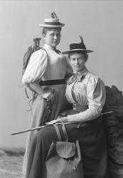 Gruppeportrett, to kvinner kledd opp til fottur. Hatt, sekk 