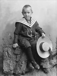 Portrett, gutt med matrosdrakt og stråhatt i hånda.