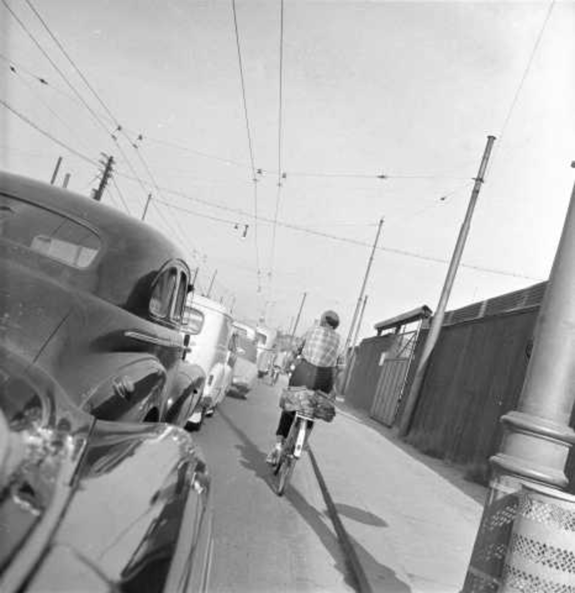 Bybilde, ant. Oslo, 1956. Gateløp med biler og syklist.