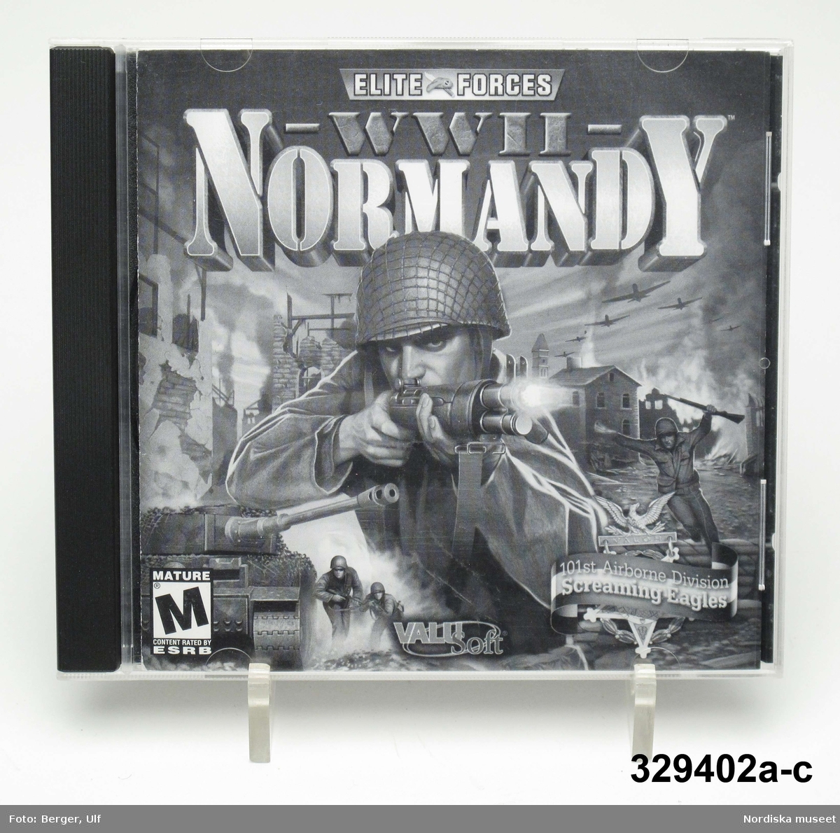 Datorspel/TV-spel (a-c) i form av CD-skiva i plastfodral och med skriftlig instruktion i fodralet. Spelets titel är "ELITE FORCES WW II NORMANDY" och handlar om en miliär landstigningsoperation under andra världkriget i Normandy, Frankrike 1944.
Spelet är tillverkat och distribuerat av Valu Soft. inc som är en division inom THQ (Toy Headquaters) Inc. Utgående från copyright började spelet sannolikt tillverkas från 2001.
Spelet är märkt M / Mature/ alltså för vuxna.

a) CD-Skiva.
b) Plastfodral
c) Instruktionsblad.

Givaren (född 1996) lämnar följande upplysningar om föremålet: Han har spelat det fram till nu dvs 2008 men anger inte från när. Spelet som heter "Normandy" är ett krigsspel och går ut på att skjuta ner fiender; i detta fall "nazister"/tyska soldater.  

Föremålet ingår i projektet "Barn tar plats". Se dokumentation i arkivet D455.
/Ulf Hamilton 2008-05-22