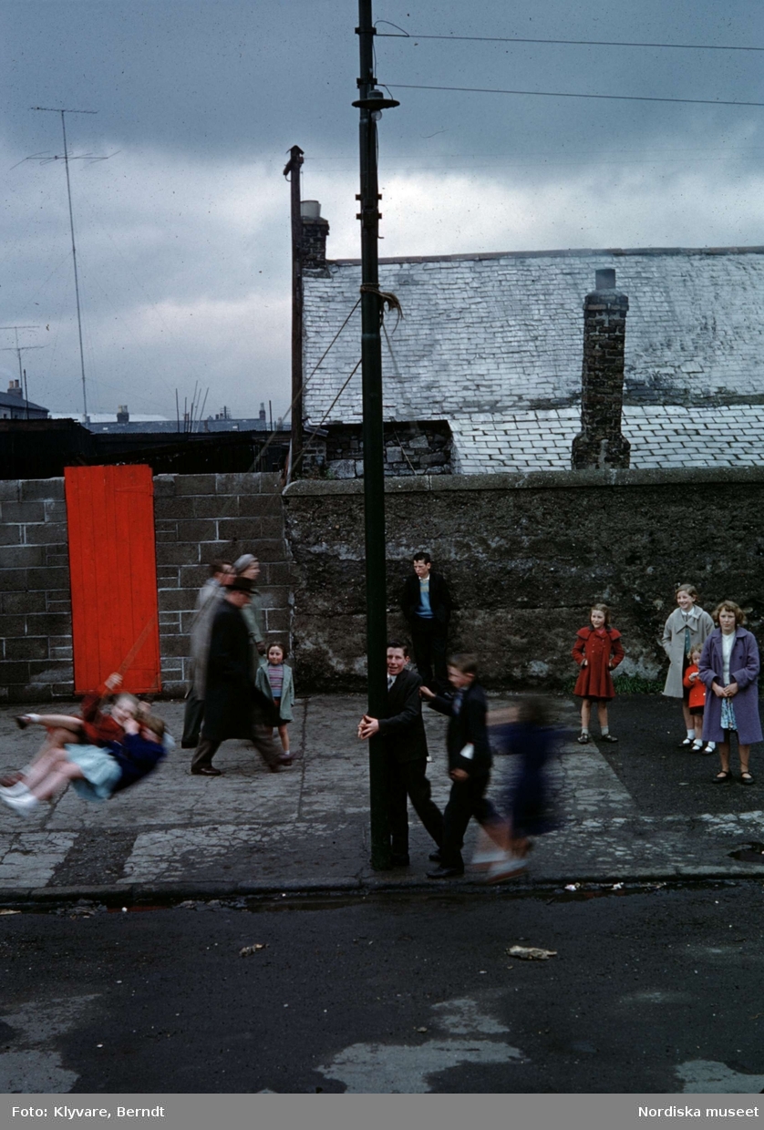 Barn som leker och gungar på stadsgata. Irland.