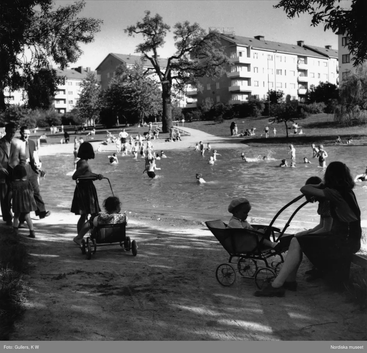 Fredhällsparken, Stockholm. Barn badar, i förgrunden kvinna med barnvagn.