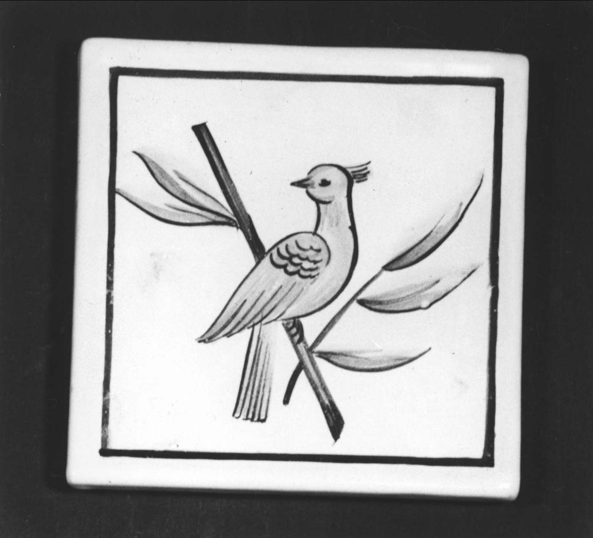 Vitglaserad med målad dekor i gult, svart och grönt föreställande en fågel på en kvist. Stämplad: S:T ERIK UPSALA. Målat i brunt : P 110.


