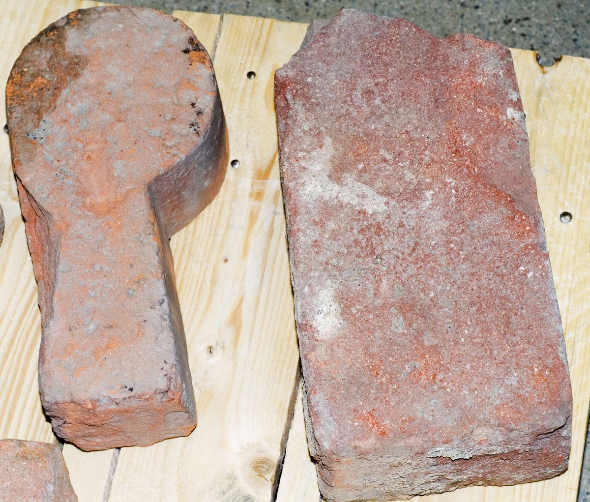 Två tegelstenar och tre formtegel av rödbrännande lergods.