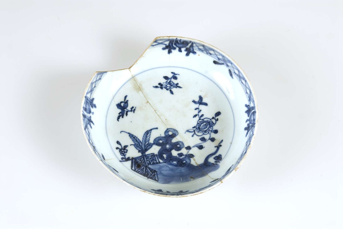 Tallrik av porslin. Kinesisk, liten djup. Tallriken har ljusblå glasyr med blå dekor, bland annat i form av blommor.
Tallriken är märkt "1944 EC", "Fr. Cederströmska fideikom." och "Beatelund".