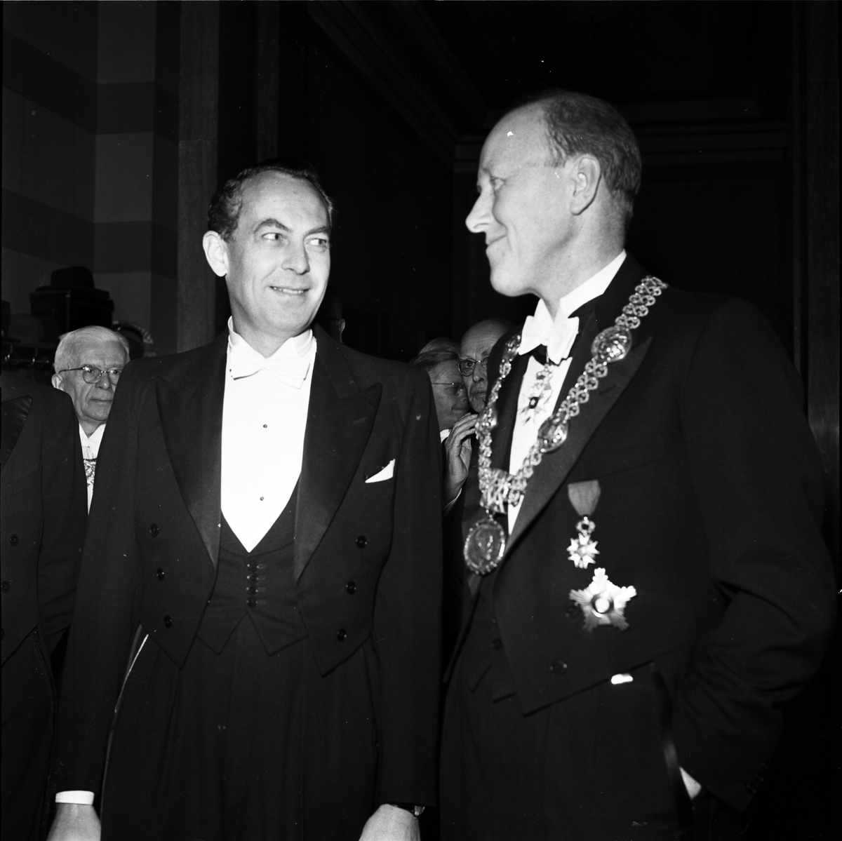 Rasbiologens nye chef Jan Arvid Böök tillsammans med Uppsala universitets rektor Torgny Segerstedt i Universitetsaulan, Uppsala 1957. I bakgrunden professor Nils von Hofsten