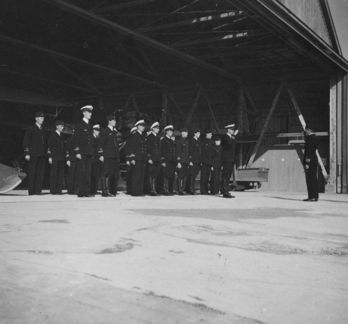 Chefen för F 2 Roslagens flygflottilj, Herman Sundin, inspekterar marinspaningskursen på Fårösund, 1938. Hälsning av manskap vid hangar.