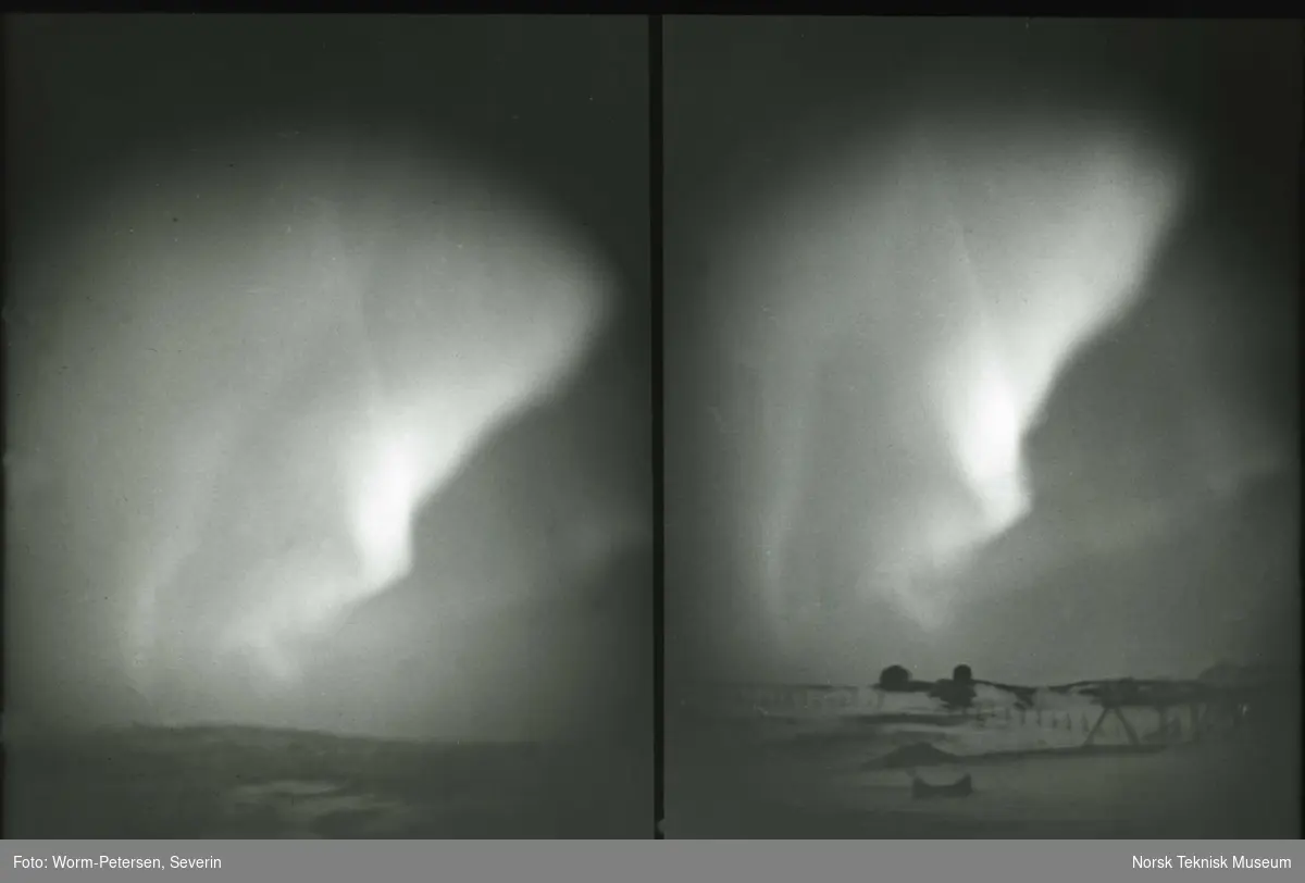 Nordlys over en åsside.