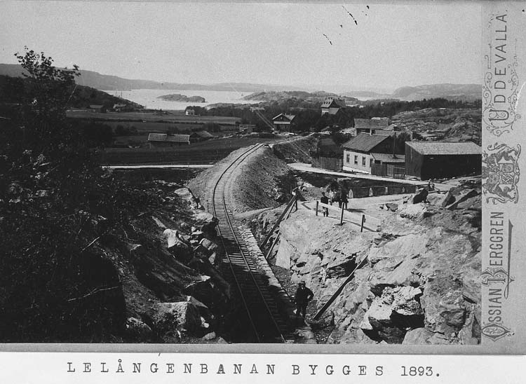 Tryckt på kortet: "Lelångebanan bygges 1893".
Enl. tidigare noteringar: "Vy mot väster i Uddevalla, Lelångenbanans byggande år 1893".
