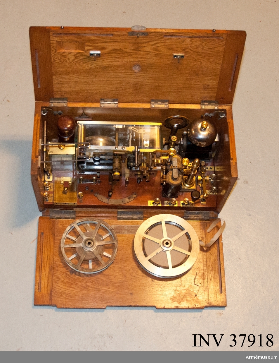 Grupp H I.

Morsetelegrafapparat bestående av åskledare, telegraferingsnyckel, galvanometer, skrivapparat, elektromagneter, väckverk, trevägsomkopplare, strömledare och pappersrullhållare.

För transport insatt i låda av trä med tre nedfällbara sidor.