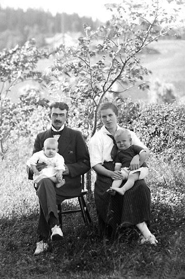 Enligt senare noteringar: "Familj sittande på pinnstolar i trädgård. Rudolf i Närestad. 
Kortet taget den 10 augusti 1920." (BJ)