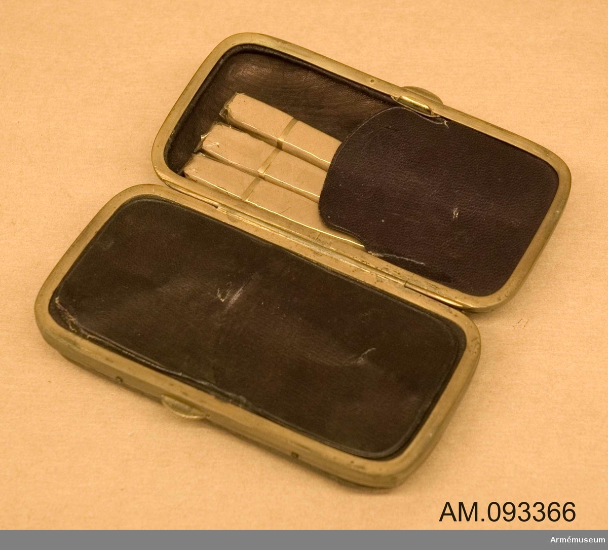 Bär på belgiska stämplar. Förvaras i svart låda fodrad med lila sammetstyg tillsammans med tre stycken cigarrer och fem stycken mindre patroner.