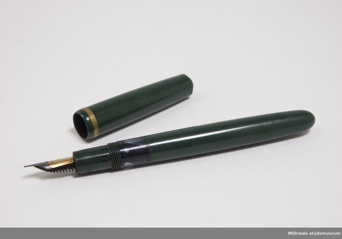 Reservoarpenna av grön plast. Pennans skaft är en behålllare som kan fyllas med bläck.  När pennan används rinner bläcket ner i pennans spets och fördelas ut i skriften. Man fick inte trycka för hårt, då kunde det bli "bläckplumpar". 
Pennan användes av Hanni Werner vars initialer står inristade i pennans skaft.