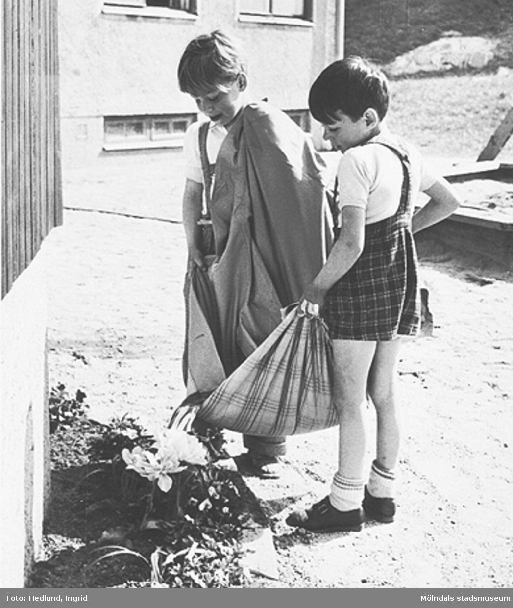 Två flickor vattnar blommor vid ett daghem i Guldheden, Göteborg. Sent 1940-tal.