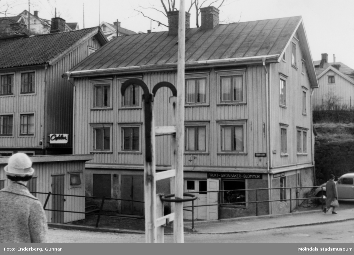Huset byggdes troligen på 1860-talet, okänt årtal. I bottenvåningen säljs frukt, grönsaker och blommor. Till höger skymtar Arvid Anderssons cykelaffär och cykelverkstad på Götaforsliden 4.