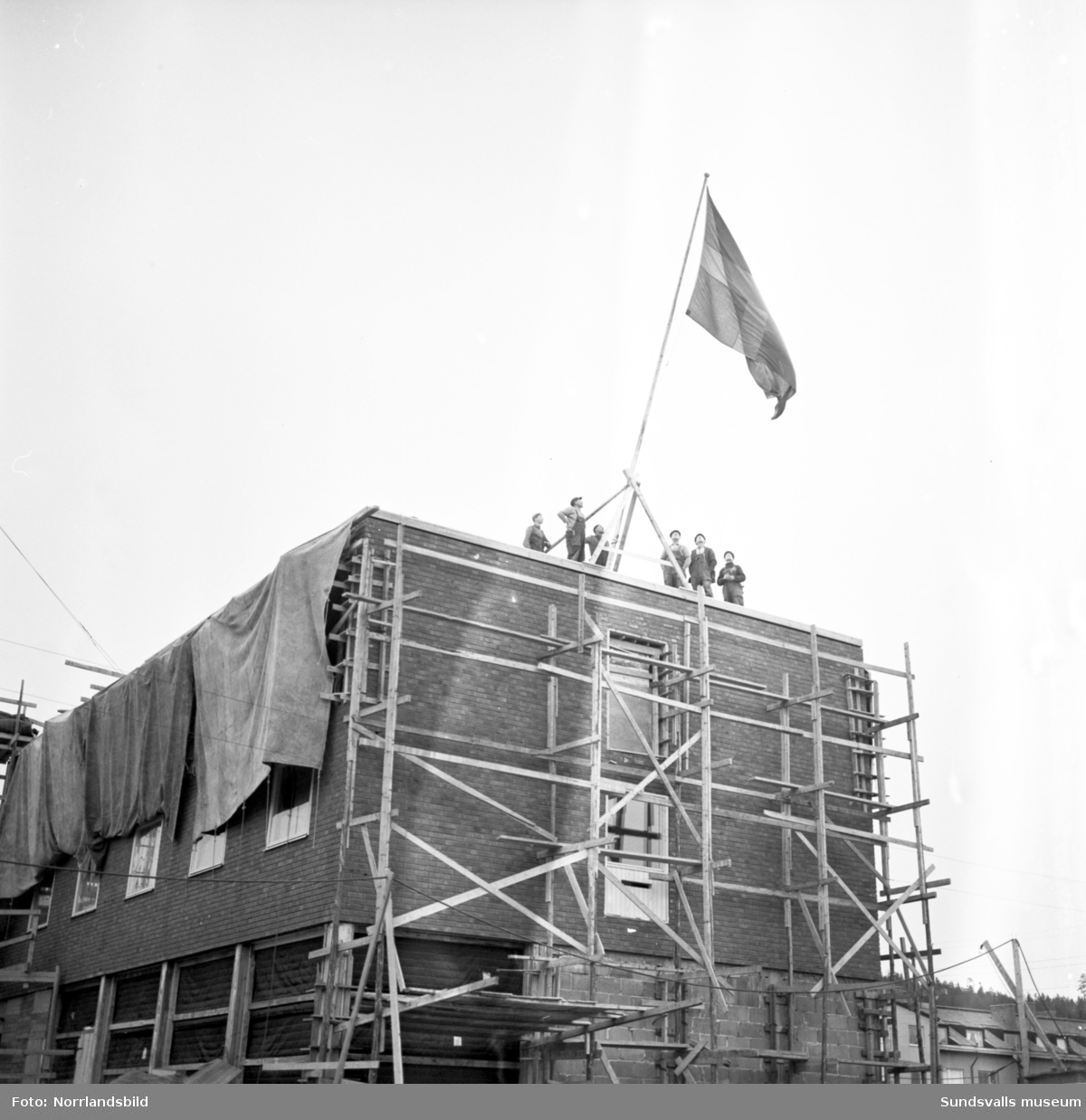 Taklagsflaggning för nya Folkets hus i Skönsberg, Medborgargatan. Bygget startade den 1 april 1957, huset stod klart 13 månader senare och invigdes med pompa och ståt den 13 september 1958.