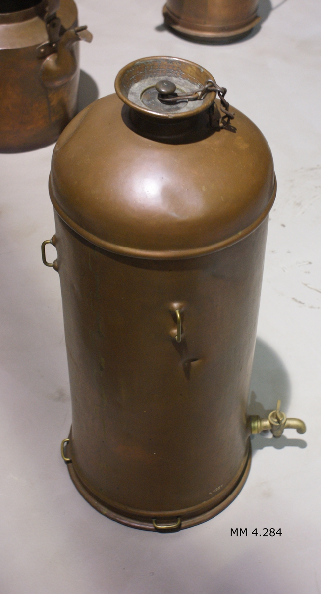 Cistern, av koppar, för olja. Cylindrisk. Försedd med avtappningskran och 4 st rekt. upphängningsanordningar av mässing. Märkning: "A.F.Hübenette No 280 Stockholm".