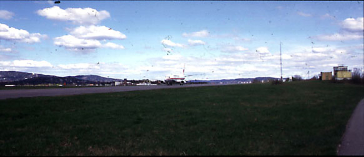 Lufthavn, 1 fly på bakken, LN-BRR Boeing 737-500 "Halvdan Svarte" fra Braathens Safe. Skrått forfra. Bygninger bak.