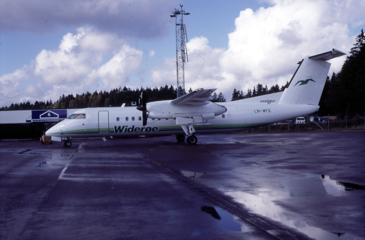 Lufthavn, 1 fly på bakken, DHC-8 (Dash 8) -311 LN-WFE fra Widerøe.  Flere kjøretøyer og 1 flyplassbygning i bakgrunnen.