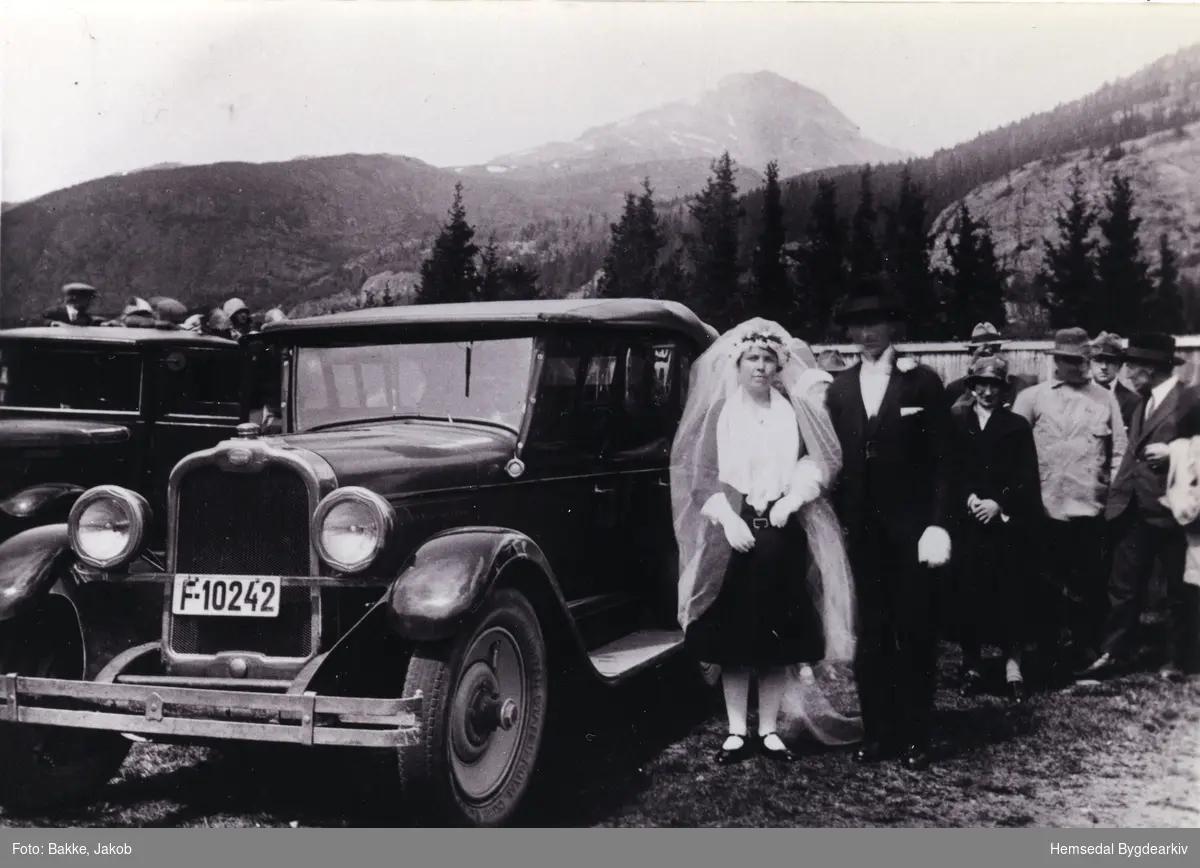 Biletet viser brureparet Oline, fødd Hulbak , og Wilhelm Wøllo utanfor kyrkja i 1930.  Bilen er ein Oakland 1927 mod ( tilhøyrande Handelsbetjent Lars Juvet.