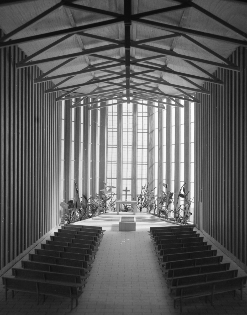 Krematorium i Lund, modell
Interiör. Mittgång mellan bänkrader, i fonden kor med ljus från höga fönster