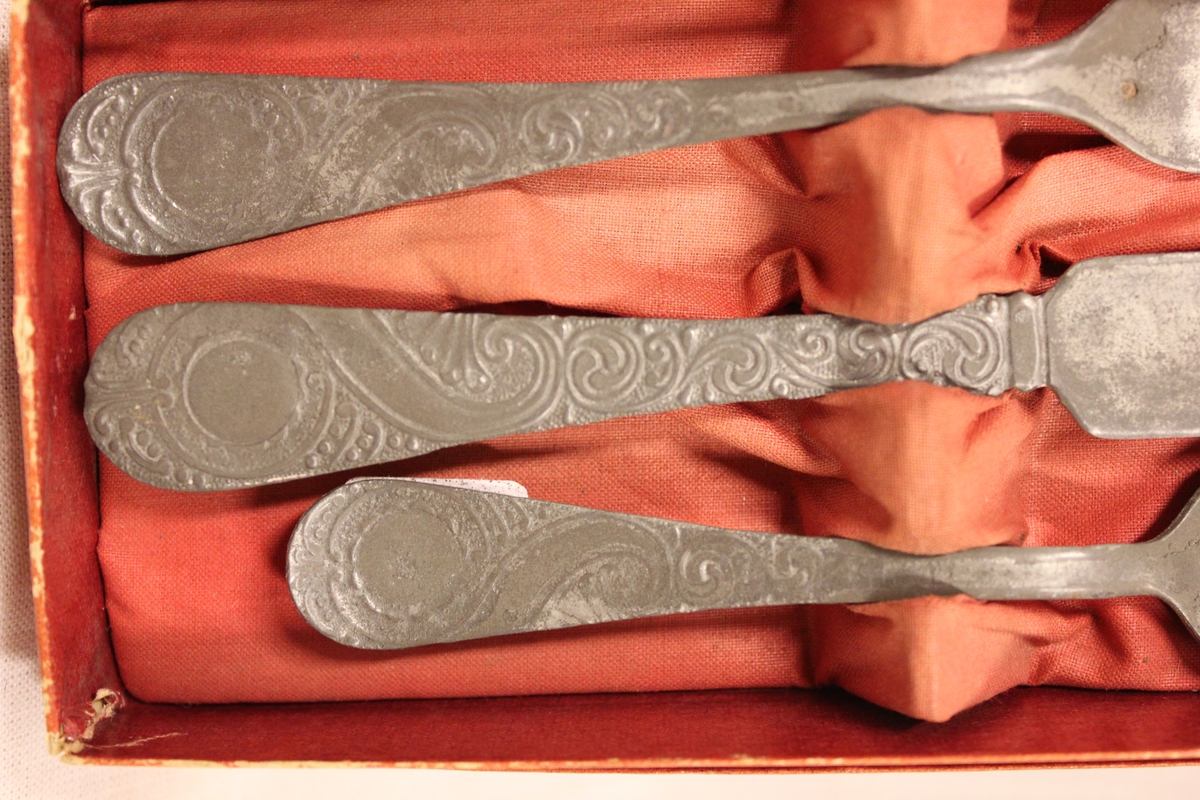Et etui i rød papp med stoff ini. En gaffel, kniv og skje. Fra tante "Dagmars hus" i Svennevik.