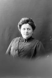 Studioportrett av en kvinne i halvfigur.