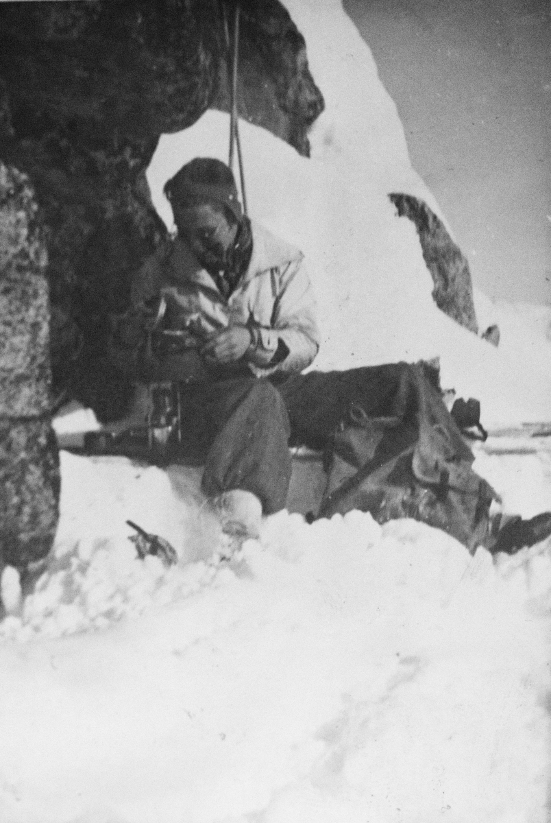 Kvinne eller mann som er på skitur tar en pause ved en bergrabbe.