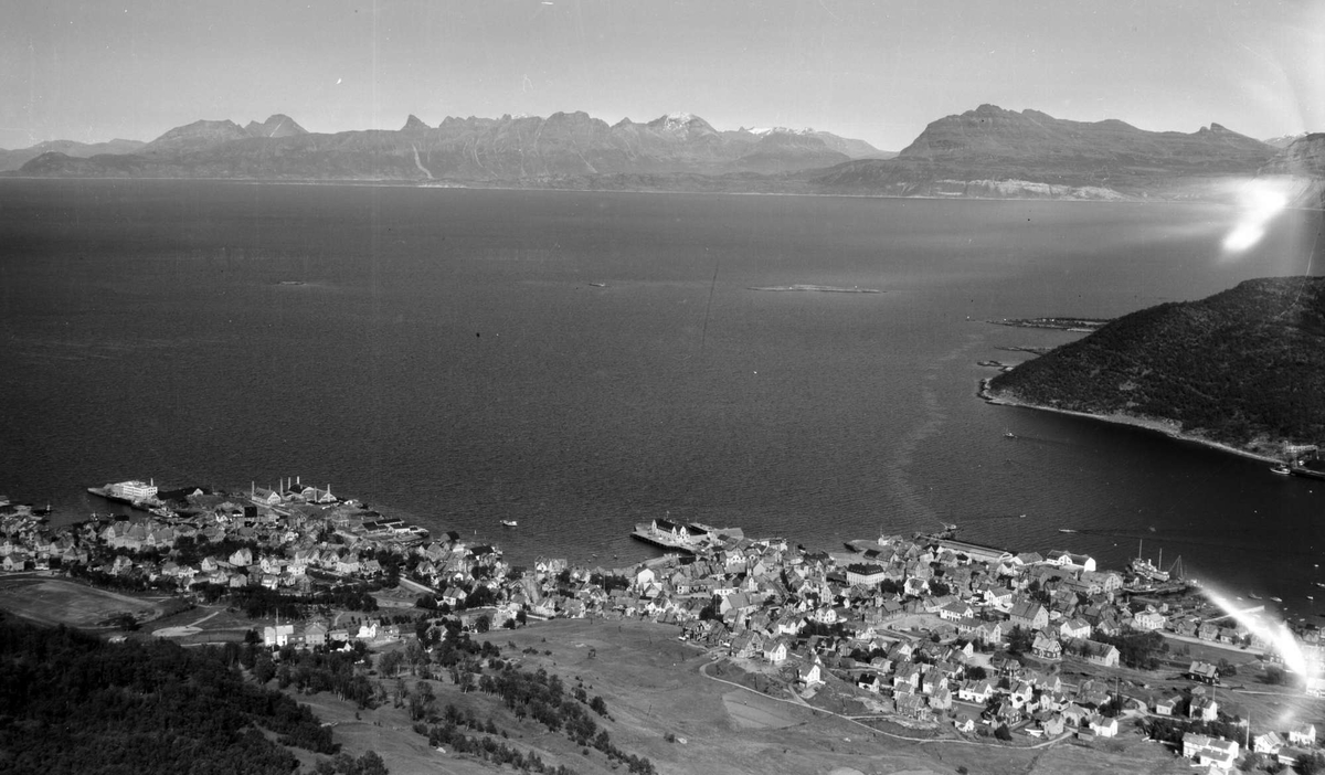 Flyfoto av Harstad med Rolløya i bakgrunnen.