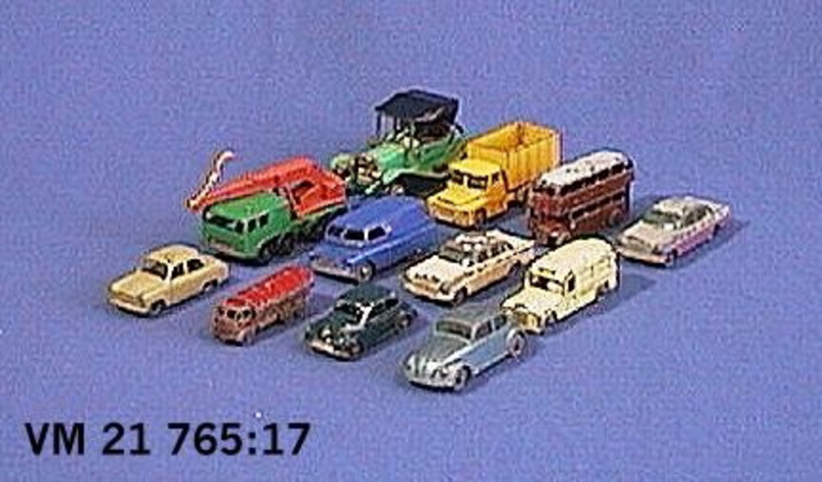 En av 12 st. leksaksbilar av metall tillverkade av Lesney Products & Co. Storbritannien.
Förutom personbilar finns en tankbil, en dubbeldäckad buss, en kranbil samt en lastbil. Bilarna är tillverkade under 1960-70 talet och är samtliga av metall. Flera av bilarna är hårt slitna.
Längd 5,2-8,2 cm.