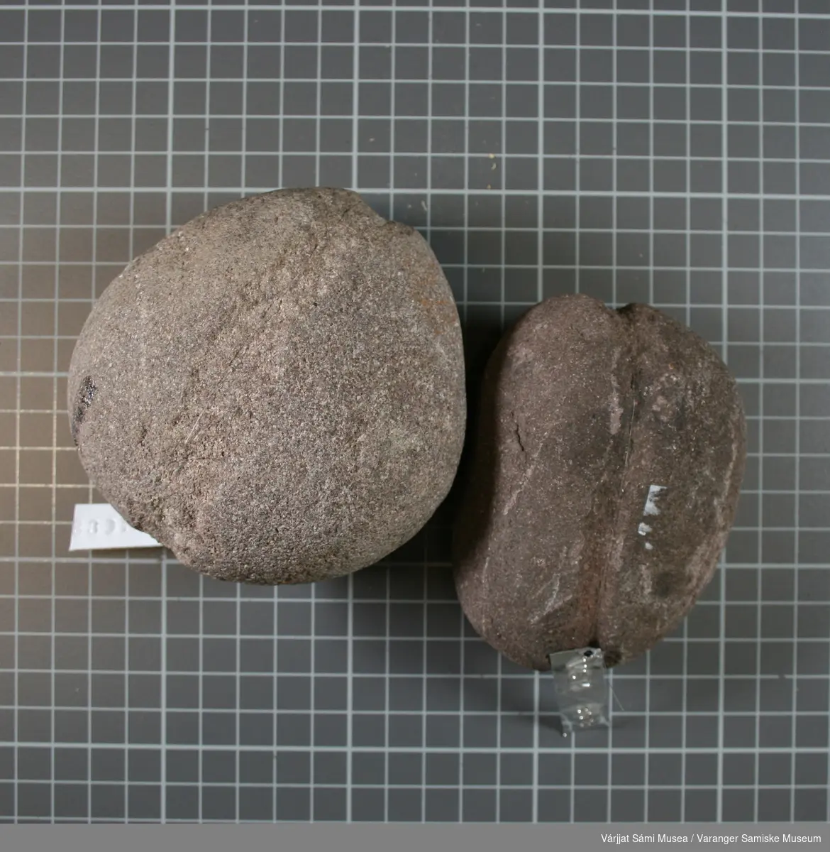 To søkke/synkesteiner, brunlig farge. Har et spor for tau over midten. Den ene steinen større, vekt ca. 300 gram og 100 gram.