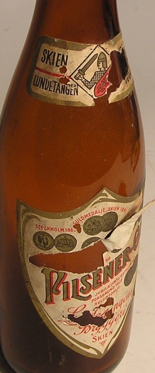 Flaske med sylindrisk korpus, innsnevrer til lang smal hals.