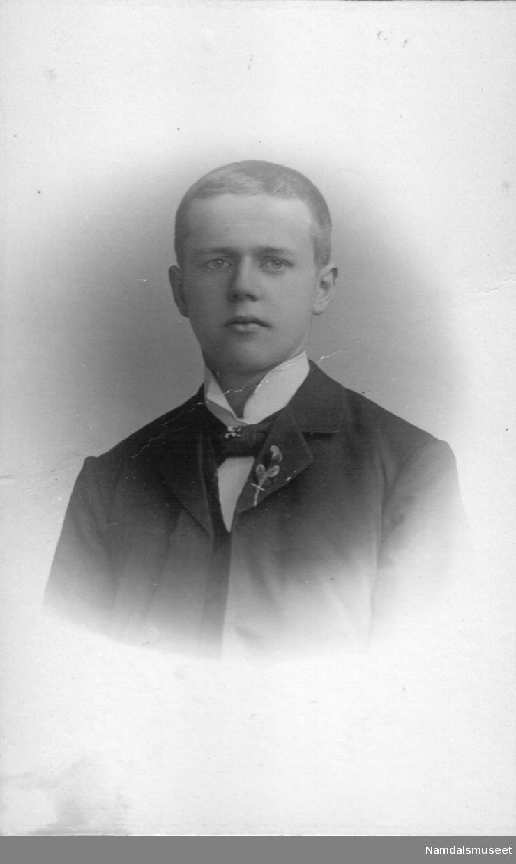 Portrett av en ung mann med blomst i jakkeslaget.