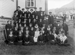 Gruppebilde av konfirmanter utenfor Tysfjord kirke. En prest