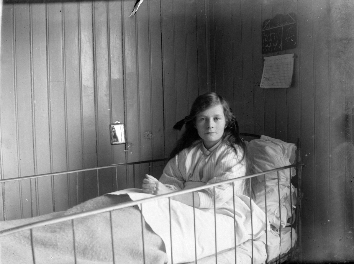 Bilde av en ung jente i sykehusseng.