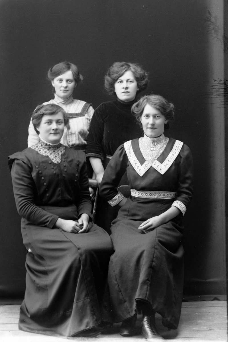 Studioportrett av fire kvinner i helfigur.