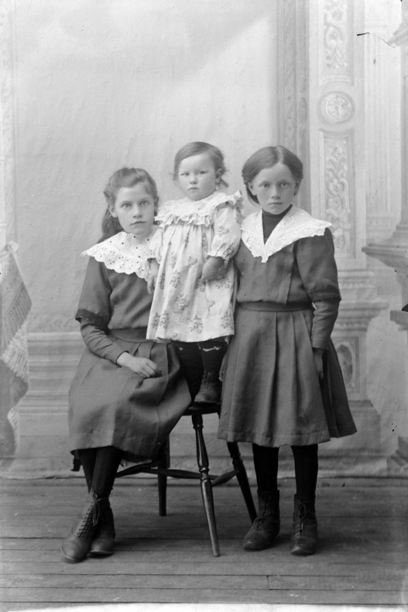Studioportrett av tre barn i helfigur.