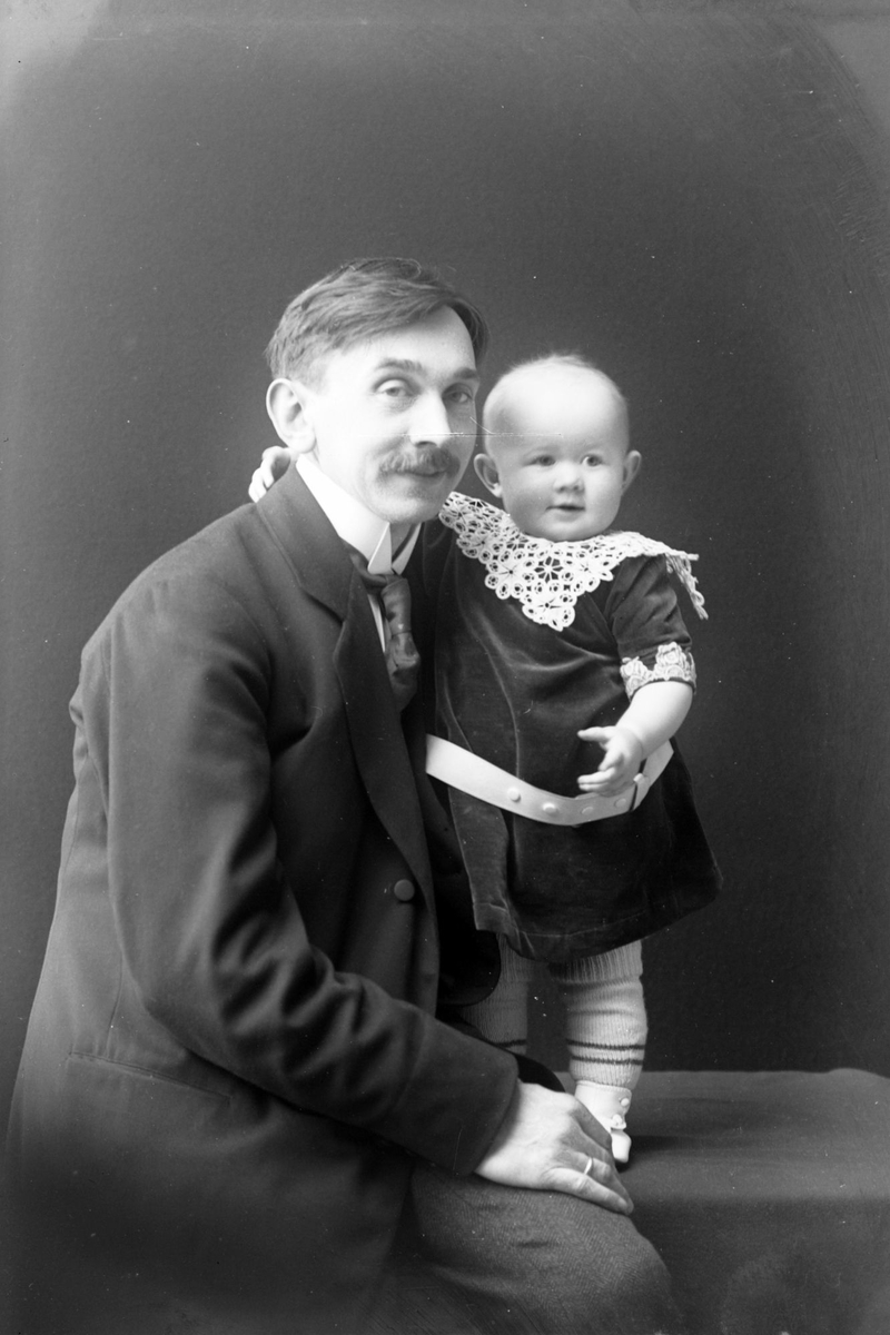 Studioportrett av en mann med et barn.
