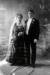 Studioportrett i helfigur av et brudepar.